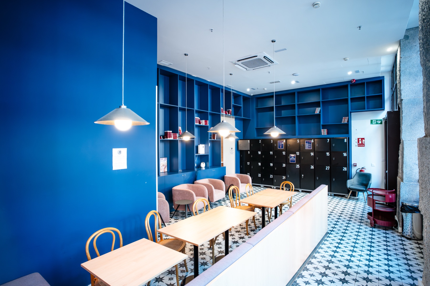 The hostel dining room with a long table and red lamps