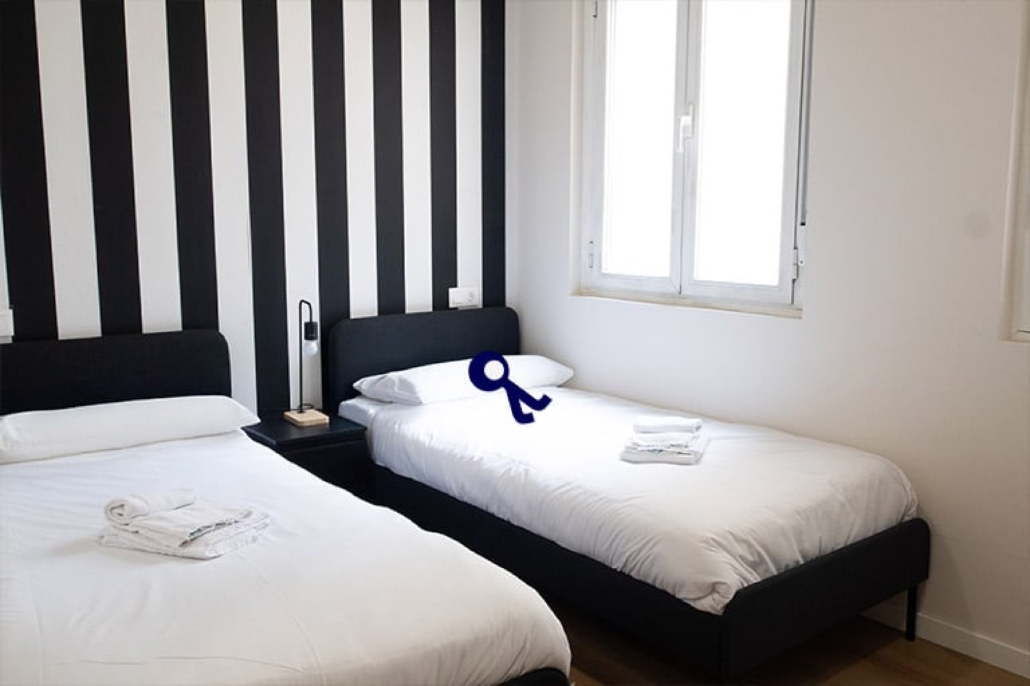 Private double room with two single beds and a striped wall