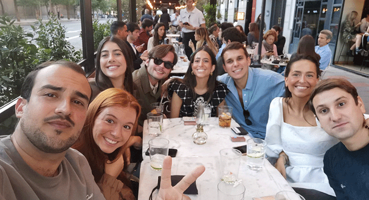 Grupo de amigos disfrutando de una cena al aire libre en una terraza de Madrid con ambiente animado.